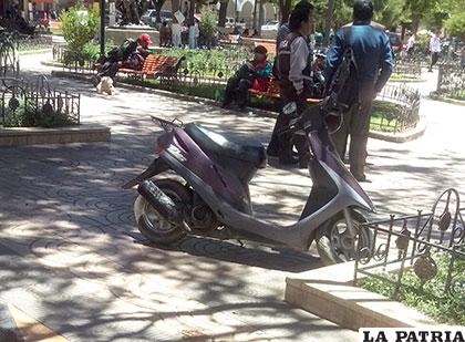 La motocicleta fue parqueada al lado de una jardinera de la plaza