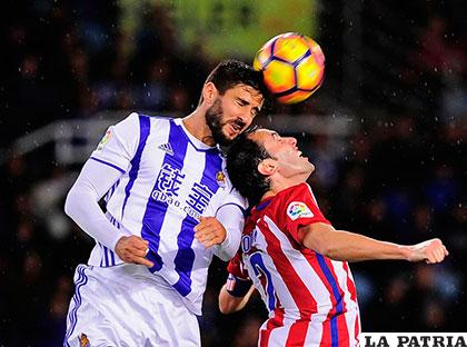 Raúl Navas y Diego Godín en la disputa de la pelota
