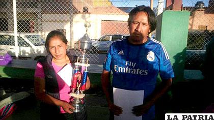 El dirigente Ayvar Gonzales entrega en trofeo a la capitana del equipo de Cuadra Doce
