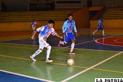 David Quisbert avanza con balón dominado ante la mirada de 
Jesús López