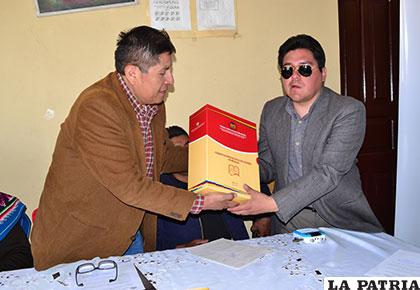 Presidente del TCP, Macario Cortez (izq), entrega el texto al presidente del IBC Oruro