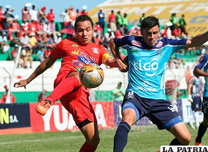 Gualberto Mojica intenta rematar ante la marca de su rival