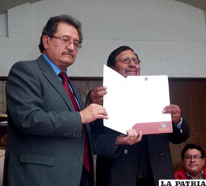 Edgar Bazán, entrega la resolución administrativa a un beneficiario