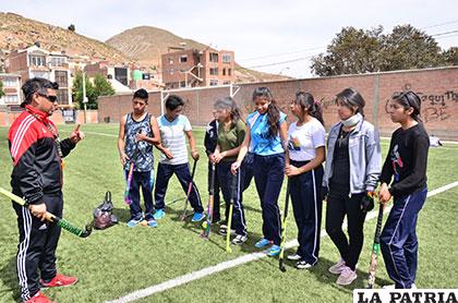Deportistas que practican el hockey en Oruro