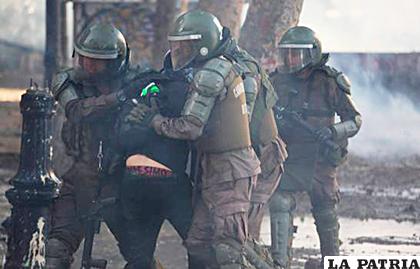 Policía antidisturbios mientras arrestan a un manifestante, en Santiago de Chile /EFE
