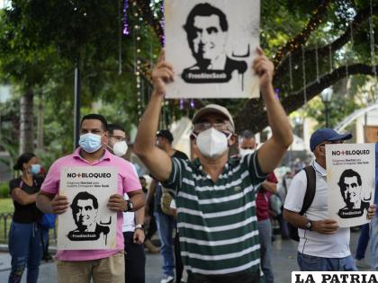 La gente sostiene carteles con la imagen del empresario Alex Saab durante una manifestación exigiendo su liberación en Caracas /AP Foto /Ariana Cubillos