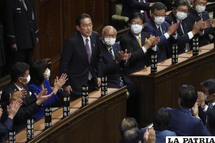 Fumio Kishida (centro) inclina la cabeza tras ser reelegido primer ministro de Japón en la cámara baja /AP Foto /Eugene Hoshiko