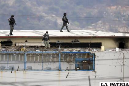 El cuerpo de un preso es rodeado por policías en el techo de la Penitenciaría del Litoral /Foto AP /José Sánchez