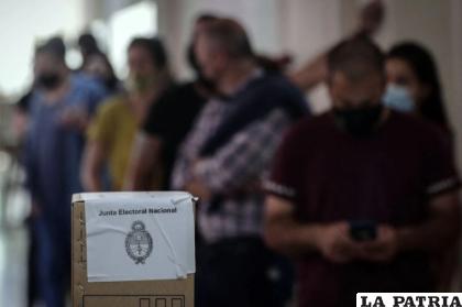 Un grupo de personas espera a votar en un colegio electoral en Buenos Aires (Argentina) /AFP