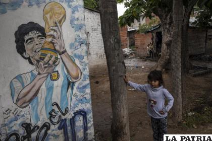 Mía, de 6 años, frente a un mural con la imagen del fallecido astro Diego Maradona /AP Foto /Rodrigo Abd