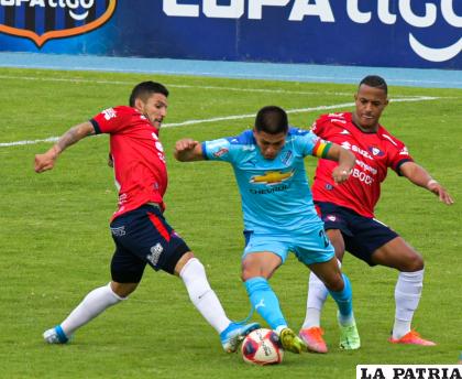 Erwin Saavedra intenta eludir a sus marcadores /APG