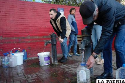 Personas llenan contenedores con agua de las bombas de agua públicas /AP Foto /Sam Mednick