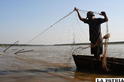 Pablito Sossa extiende nuevamente su red para tender la trampa de pesca, luego de revisar que estaba vacía / Luis Salazar
