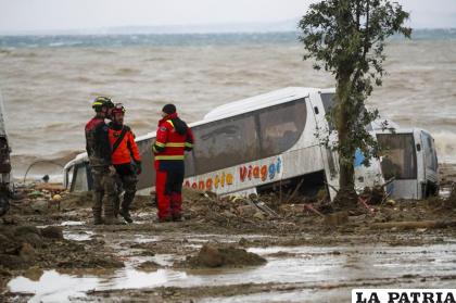 Rescatistas están junto a un autobús arrastrado por uno de los aludes de barro provocados por las lluvias intensas /AP Foto/Salvatore Laporta