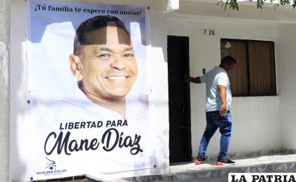 Una persona sale hoy de la casa familiar del futbolista colombiano Luis Díaz, de donde cuelga un gran cartel con la imagen de su padre, Luis Manuel Díaz, secuestrado el pasado sábado, en Barrancas, departamento de La Guajira (Colombia) /EFE/Ricardo Maldonado Rozo