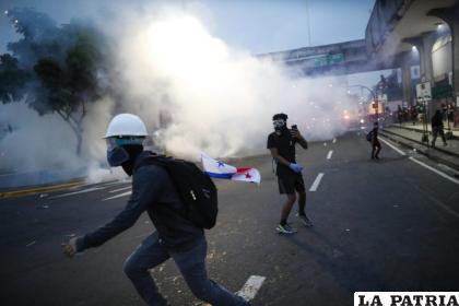 Manifestantes se enfrentan a la Policía al final de una nueva jornada de protestas contra el contrato entre el Estado y Minera Panamá, subsidiaria de la canadiense First Quantum Mineral (FQM), en Ciudad de Panamá (Panamá) / EFE