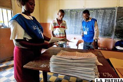 Agentes electorales colocan las papeletas de votación en un colegio electoral de Kinshasa, en la República Democrática del Congo
