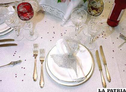 La segunda mesa será nuestra mesa principal, aquí estará nuestro plato base, los cubiertos acomodados según sea nuestro menú, los cubiertos principales, el tenedor de cena, el tenedor de ensalada mismos que estarán al lado izquierdo del palto base, el cuchillo de cena y el cuchillo de carne, serán acomodados al lado derecho del plato base. Como ya mencionamos, las copas de champagne y de vino acomodadas al lado superior de nuestro plato base, la servilleta de tela será puesta sobre el plato base nunca dentro de ninguna copa
