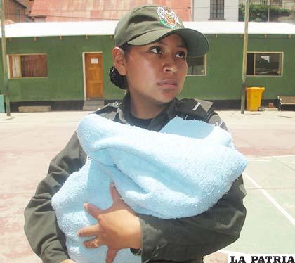 La investigadora Villanueva sostiene a la bebé que casi muere en manos de su progenitora