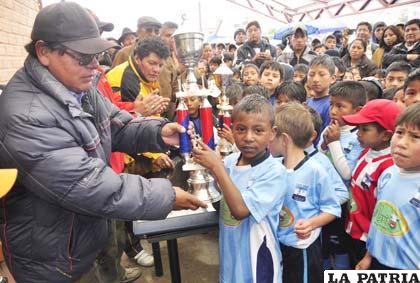 René Huallata hace la entrega del trofeo de campeón al capitán de Saavedra, Marcelo Timorán