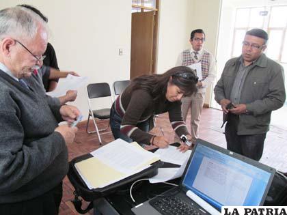 La directora del Segip, Ninoska Urquieta firma el acta de entrega de los ambientes que ocupaban en la zona Este