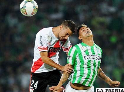 Emanuel Mammana disputa el balón con Orlando Berrío