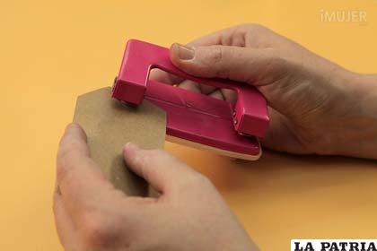 PASO 5
Usa la perforadora para hacer un orificio en la tarjetita de papel craft y coloca el sticker de oficio.