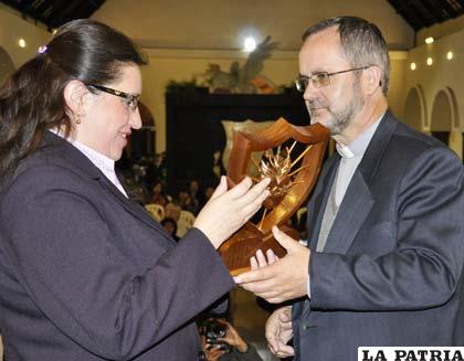 Monseñor Cristóbal Bialasik entrega la estatuilla a la directora de LA PATRIA, Ximena Miralles I.