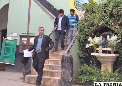 El ministro Saavedra (medio) sale de la reunión por la puerta colindante a la Felcc