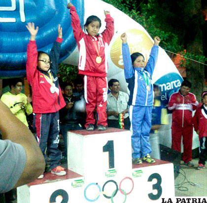Alison Bustos en el podio con la medalla bronce