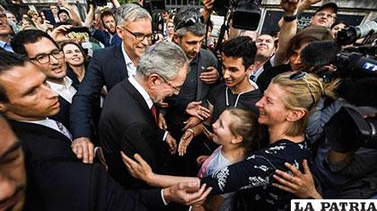 El centroizquierdista Alexander Van der Bellen (centro) saluda a la multitud en Austria