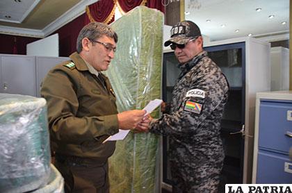 El comandante de Policía, coronel Juan José Torrelio, entrega simbólicamente uno de los colchones al comandante de la UTOP