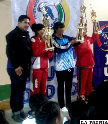 La entrenadora Hilda Martínez con el trofeo que acredita como campeón a Oruro