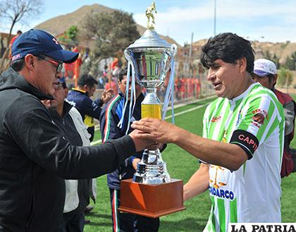 Saúl Zurita, capitán de Deportivo Itos, recibe el trofeo de campeón