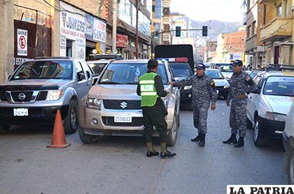 Efectivos policiales observan el estacionamiento en doble fila de un vehículo