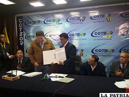 Representantes de Cotas y Coteor muestran el documento tras la firma respectiva