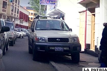 El motorizado parqueado con las llantas izquierdas sobre la vereda