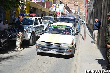 Funcionarios policiales observan la llegada del taxi implicado en el caso