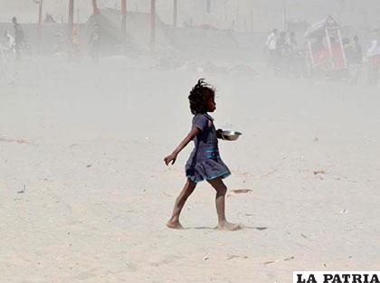 Niña atraviesa una tormenta de arena en la India. Febrero 24. Reuters/Jitendra Prakash