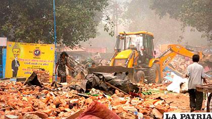 Una excavadora retira los escombros del barrio chabolista de Kathputli en Nueva Delhi, India