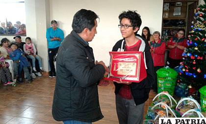 Daniel Titichoca recibe el reconocimiento de parte el titular del ajedrez orureño, Henry Titichoca
