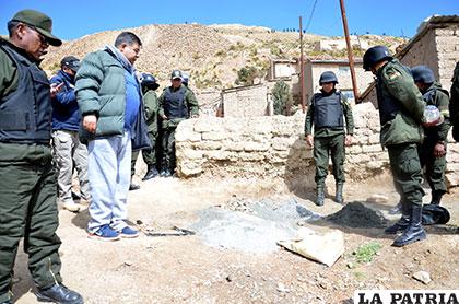 El fiscal Mario Rocha y policías observan el mineral botado en una de las calles de Cataricagua