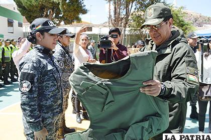 El comandante General, coronel Rodolfo Montero coloca un chaleco antidisturbios a una uniformada de la UTOP /LA PATRIA