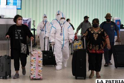 Tripulantes de un vuelo de Air China en el aeropuerto de Los Ángeles con trajes de bioseguridad /AP Foto /Jae C. Hon)