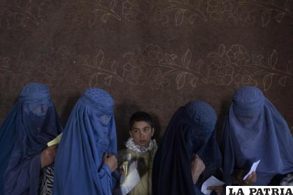 Mujeres afganas esperan recibir dinero en un centro de distribución de fondos organizado por el Programa Mundial de Alimentos en Kabul /AP Foto /Petros Giannakouris