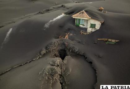 En esta imagen de archivo, vista de una fisura cerca de una casa cubierta de ceniza volcánica en la isla de La Palma /AP Foto /Emilio Morenatti, archivo
