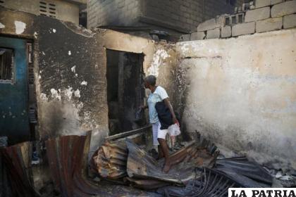 Nelly Joseph camina en su casa quemada en Cabo Haitiano, Haití /AP Foto /Odelyn Joseph