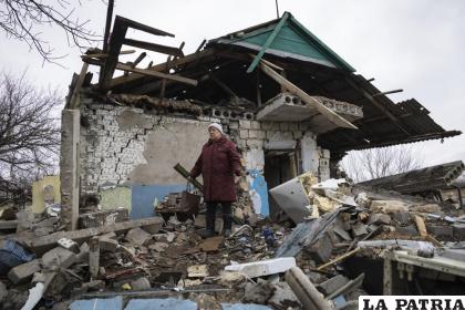 Liudmyla Momot enjuga sus lágrimas mientras revuelve los escombros de su casa, cañoneada por separatistas respaldados por Rusia en el este de Ucrania /AP Foto /Andriy Dubchak
