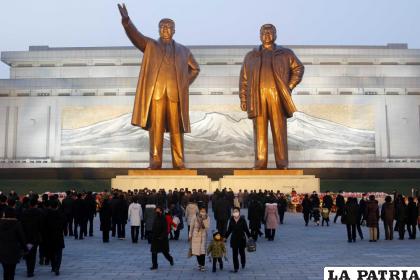 Ciudadanos norcoreanos visitan las estatuas de bronce de sus fallecidos líderes Kim Il Sung (izquierda) y Kim Jong Il /AP Foto /Cha Song Ho