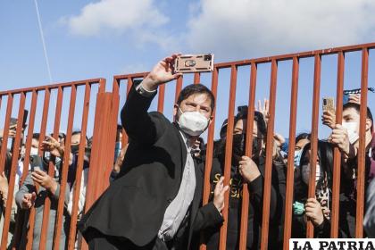 El candidato presidencial izquierdista Gabriel Boric se toma selfies con la gente fuera de un colegio electoral /Foto AP /Andrés Poblete